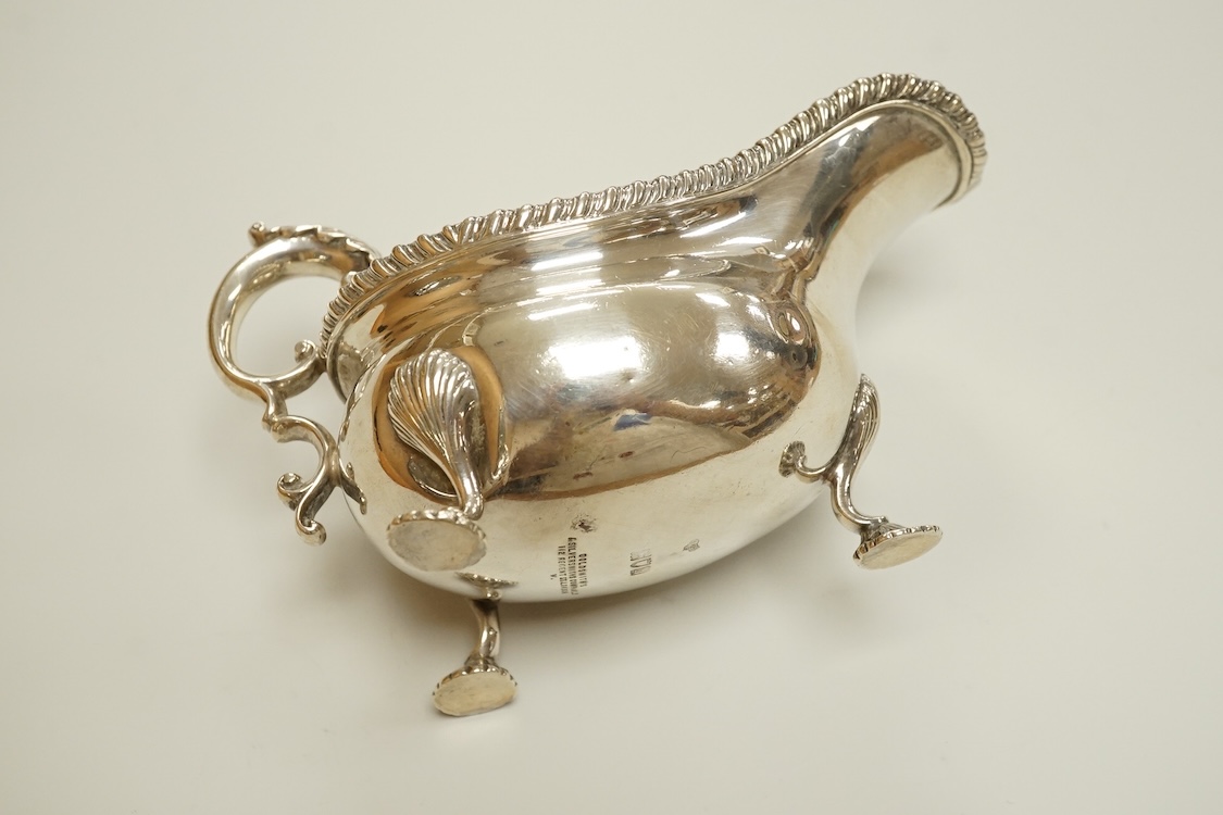An Edwardian silver sauceboat, by The Goldsmiths & Silversmiths Co Ltd, London, 1903, with flying scroll handle and gadrooned border, length 16.3cm, 9.5oz.